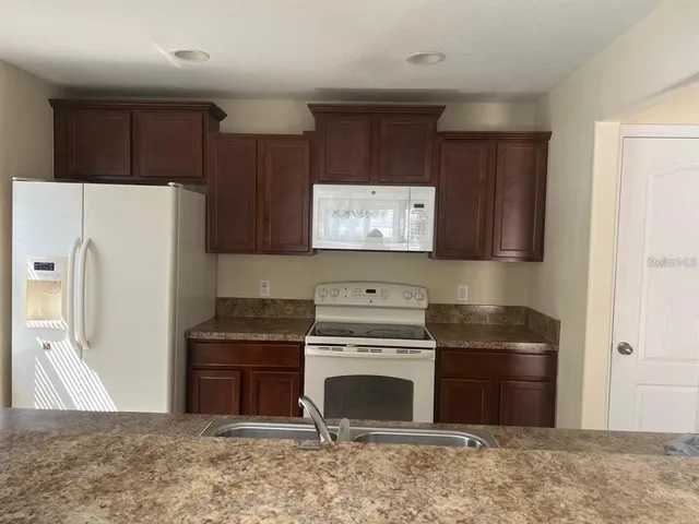 a kitchen with stainless steel appliances granite countertop a refrigerator sink and cabinets