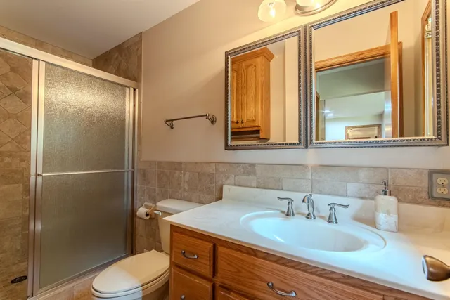 a bathroom with a granite countertop sink toilet and shower