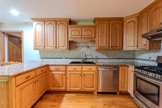 a kitchen with stainless steel appliances granite countertop a stove a sink and a granite counter tops