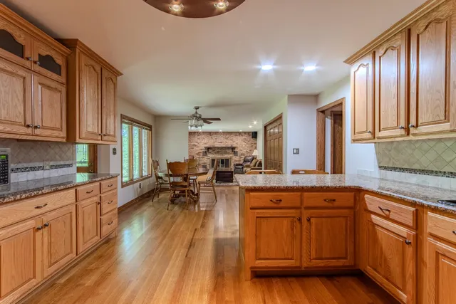 a kitchen with granite countertop lots of counter top space and wooden floors