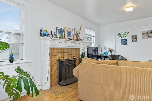 a living room with furniture a fireplace and a potted plant