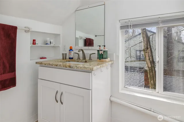 a bathroom with a granite countertop sink and a mirror