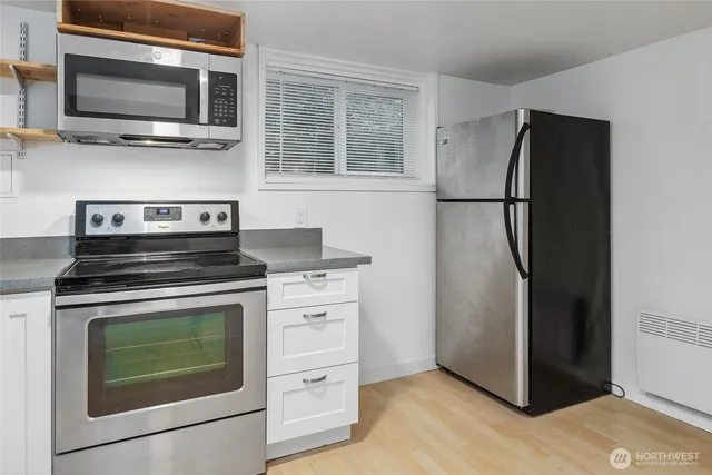 a kitchen with stainless steel appliances a stove microwave and refrigerator