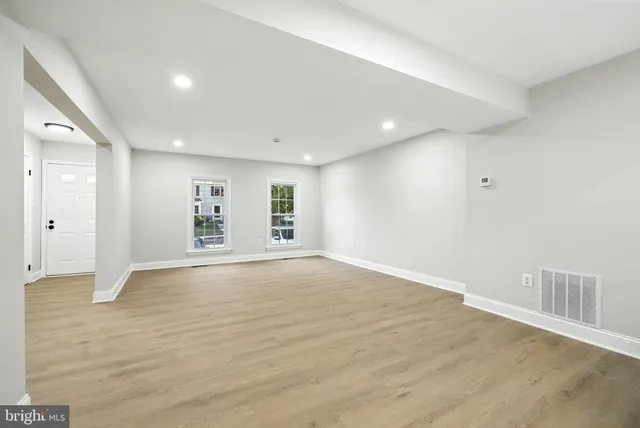 a view of a big room with wooden floor and a kitchen