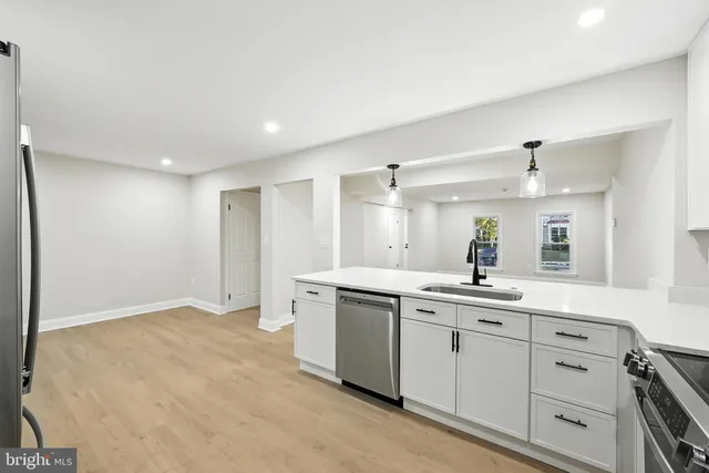a view of kitchen with stainless steel appliances granite countertop a sink and a refrigerator