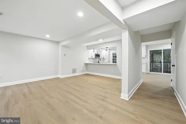 a kitchen with stainless steel appliances a refrigerator a sink a stove top oven cabinets and a dining table