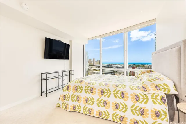 a bedroom with a bed television and a large window