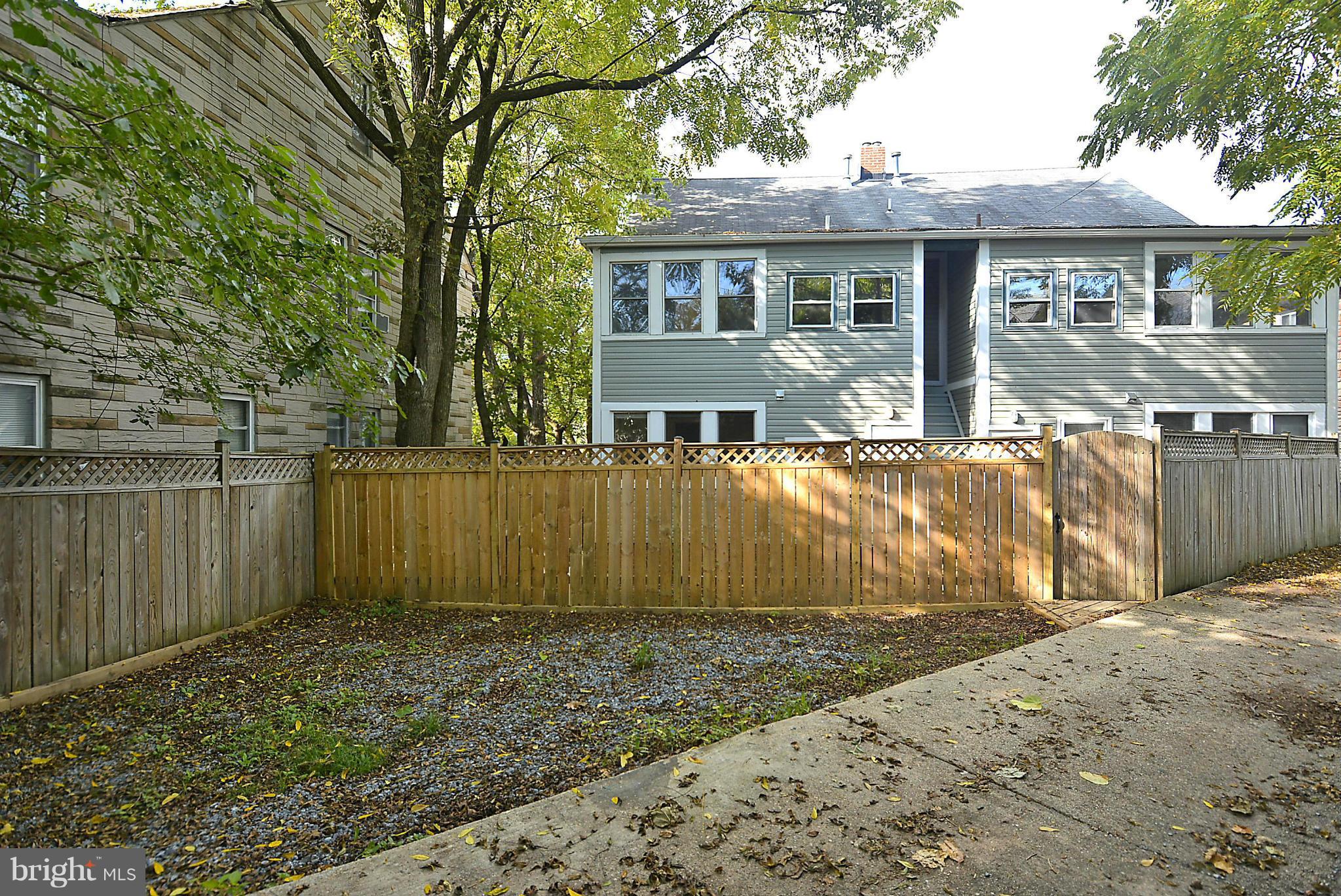 4319 River Road Northwest Washington, DC 20016 - Photo 20 of 22 a view of a house with a wooden fence next to a yard
