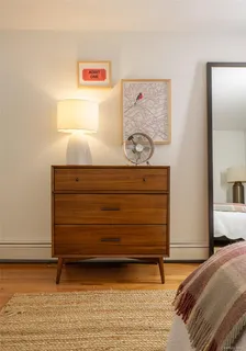 a bedroom with a bed and painting on the wall
