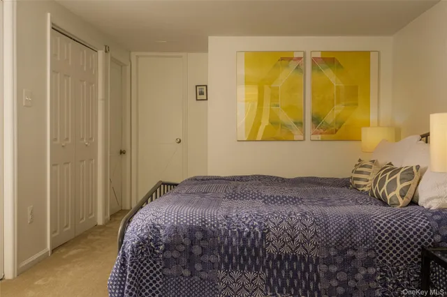 a bedroom with a bed and painting on the wall