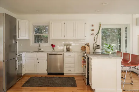 a kitchen with white cabinets and white appliances