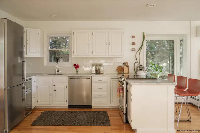 a kitchen with white cabinets and white appliances