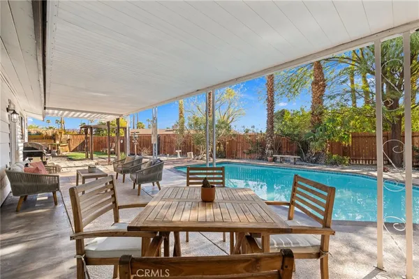a front view of a house with swimming pool having outdoor seating