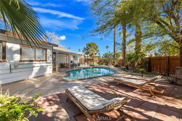a kitchen with stainless steel appliances kitchen island granite countertop a stove a sink a refrigerator and white cabinets with wooden floor