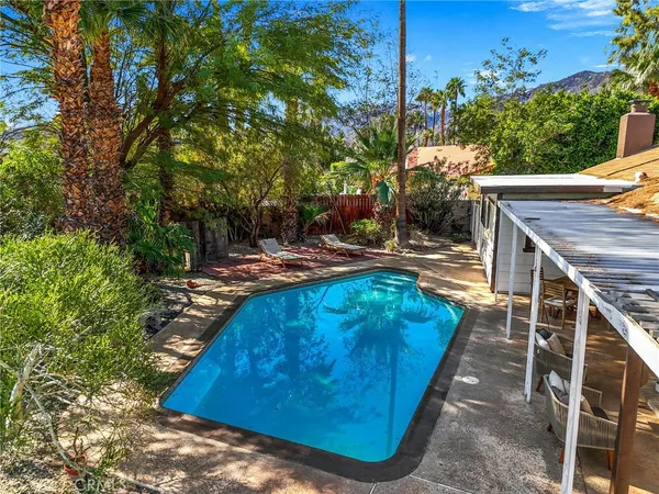a view of a house with backyard and sitting area