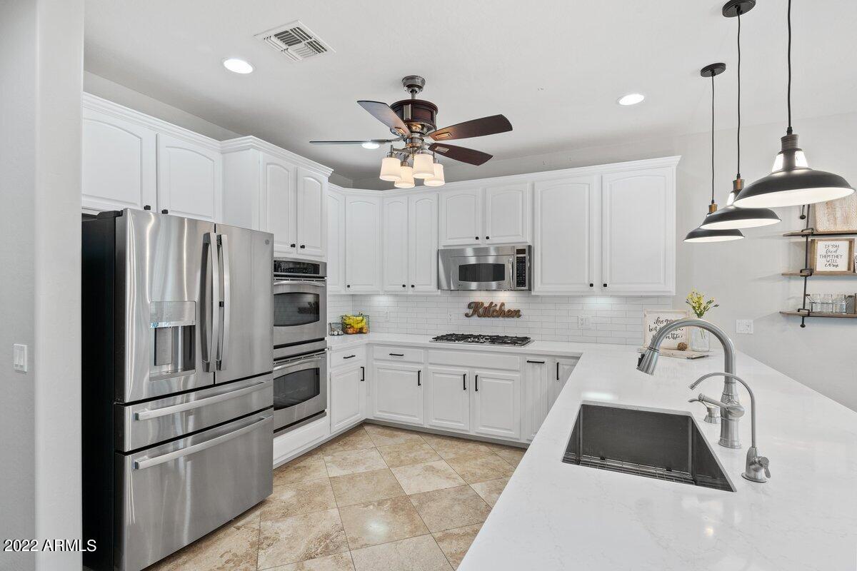 21973 East Rosa Road Queen Creek, AZ 85142 - Photo 5 of 15 a kitchen with stainless steel appliances a stove a sink and a refrigerator