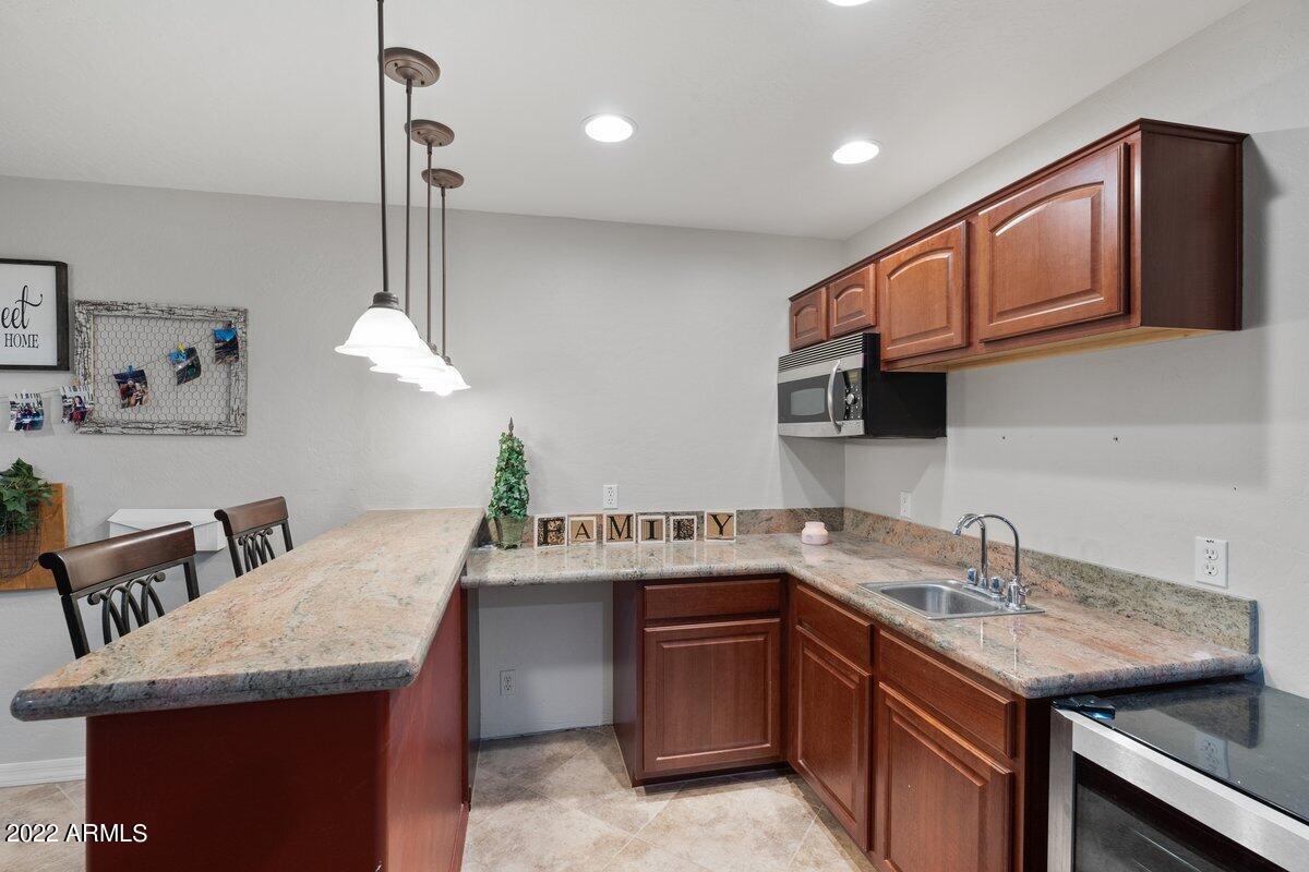 21973 East Rosa Road Queen Creek, AZ 85142 - Photo 10 of 15 a kitchen with a sink a stove and cabinets