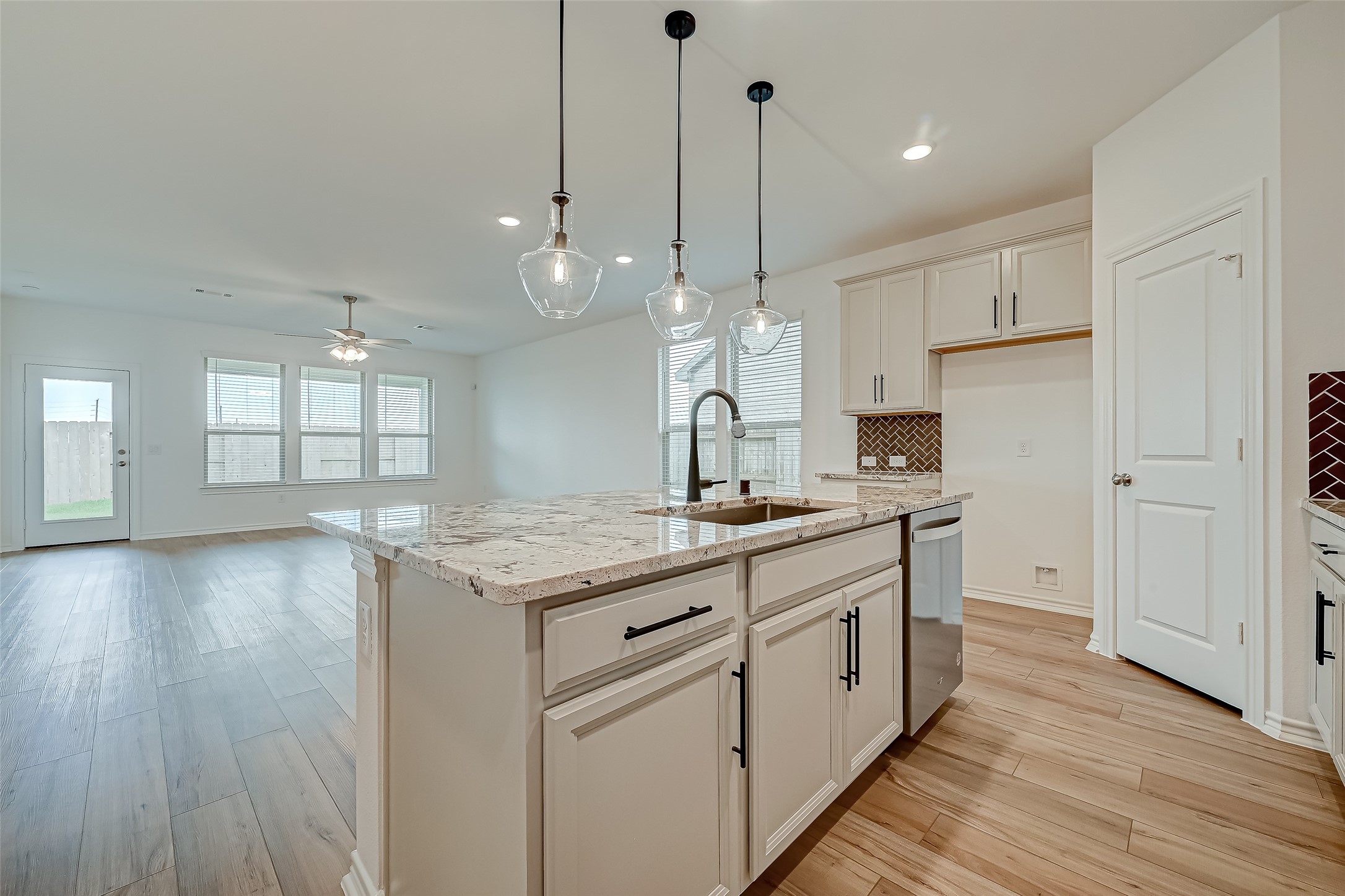 1308 Tan Gable Lane Katy, TX 77493 - Photo 12 of 30 a kitchen with stainless steel appliances granite countertop wooden floors sink and cabinets