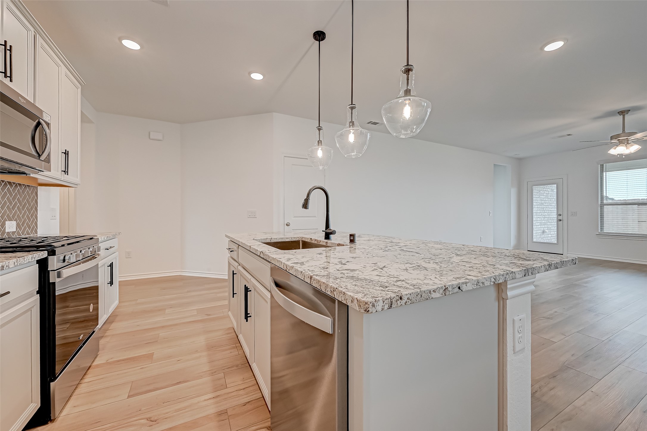 1308 Tan Gable Lane Katy, TX 77493 - Photo 13 of 30 a kitchen with a sink a stove and a refrigerator