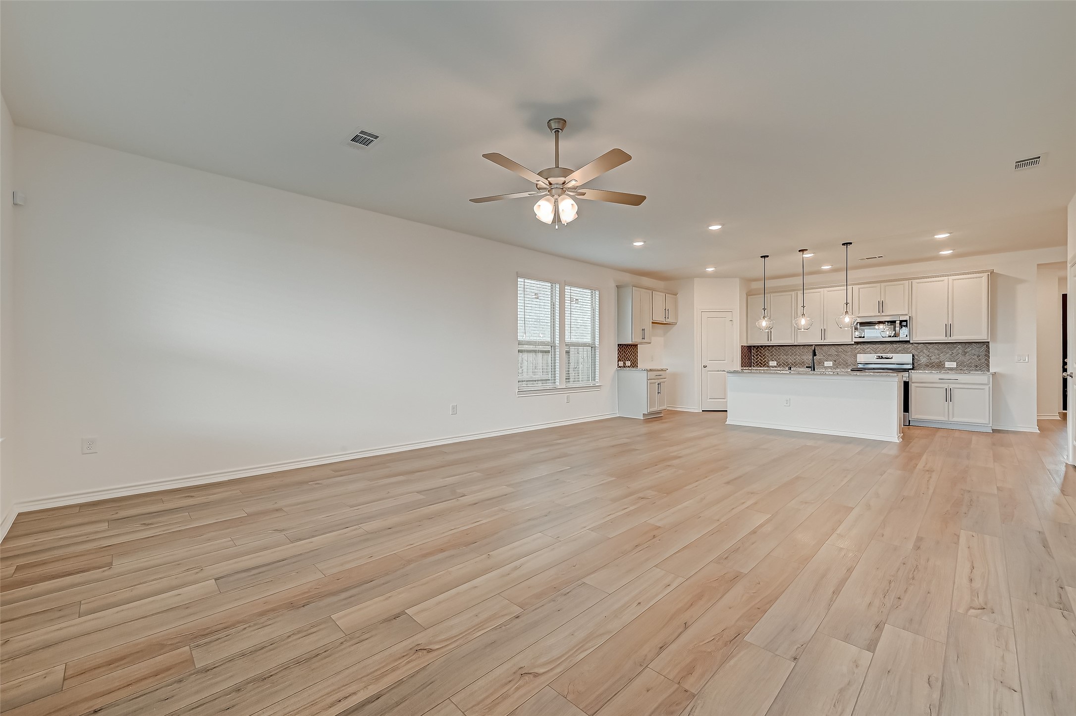 1308 Tan Gable Lane Katy, TX 77493 - Photo 8 of 30 a view of an empty room and kitchen view with wooden floor