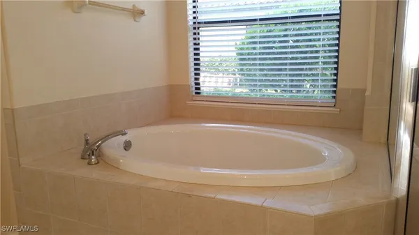 a white bath tub sitting in a bathroom next to a window