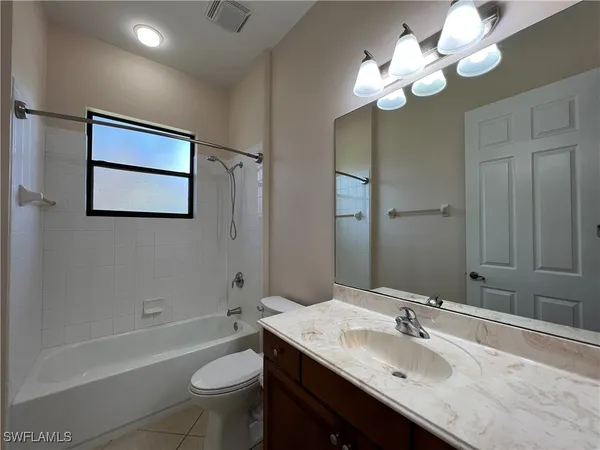 a bathroom with a granite countertop sink a toilet and bathtub