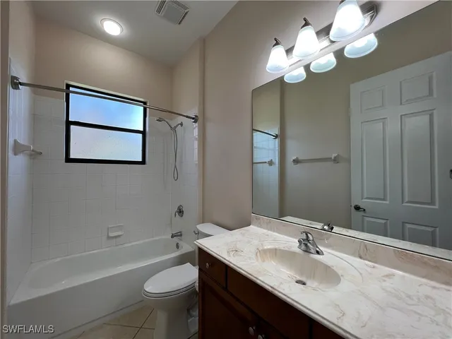 a bathroom with a granite countertop sink a toilet and bathtub