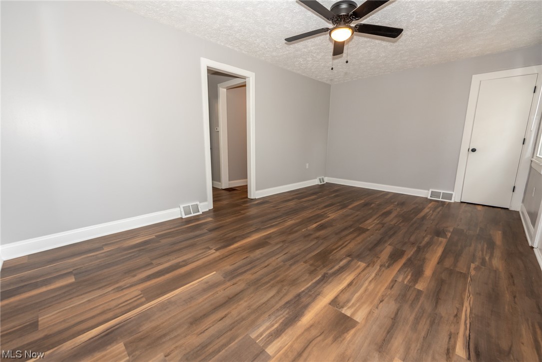 805 Gougler Road Akron, OH 44319 - Photo 7 of 21 Empty room with dark wood-type flooring, a textured ceiling, and ceiling fan