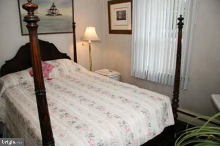 4119 Raleigh Road Pikesville, MD 21208 - Photo 5 of 15 a bedroom with a bed and a lamp on table