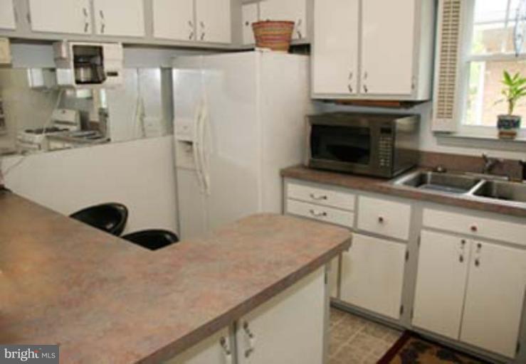 4119 Raleigh Road Pikesville, MD 21208 - Photo 8 of 15 a kitchen with a sink a stove and cabinets