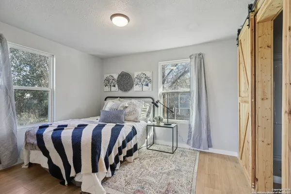a bedroom with a bed lamp and a large window