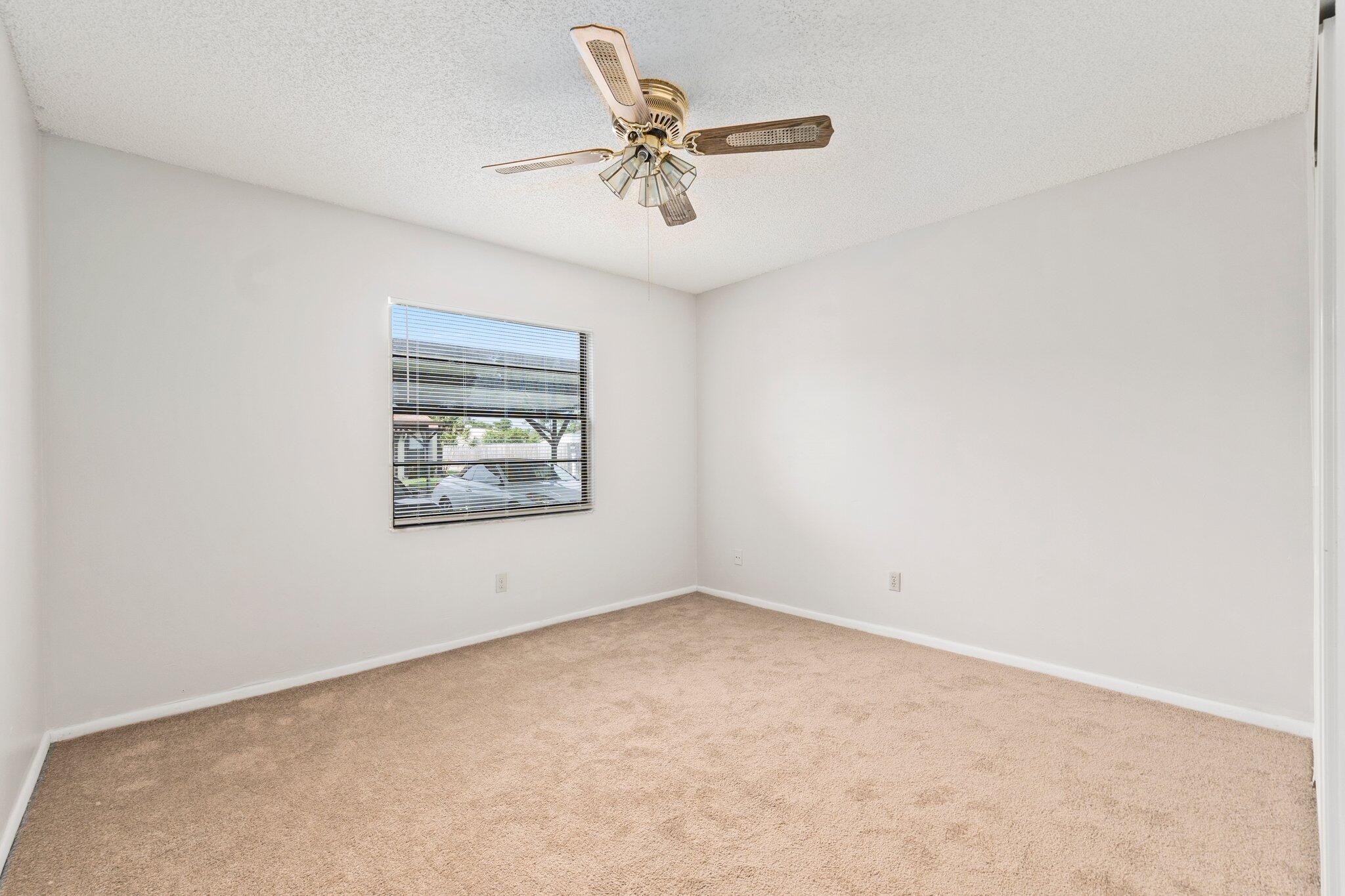 6012 Indrio Road, Unit E2 Fort Pierce, FL 34951 - Photo 18 of 25 an empty room with a ceiling fan and window