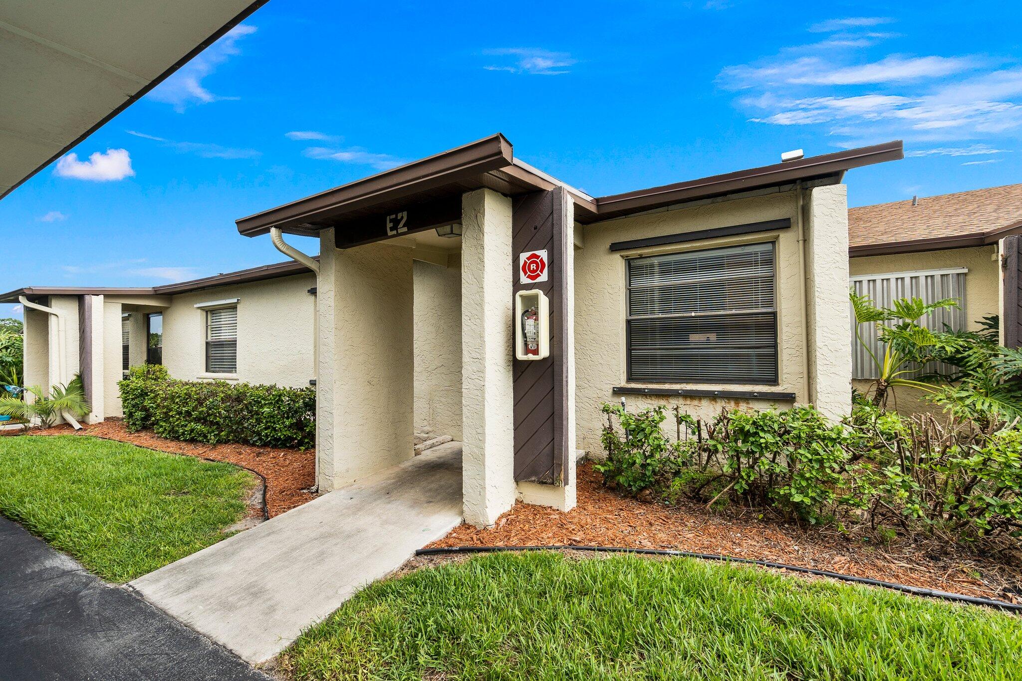 6012 Indrio Road, Unit E2 Fort Pierce, FL 34951 - Photo 2 of 25 a front view of a house with a yard