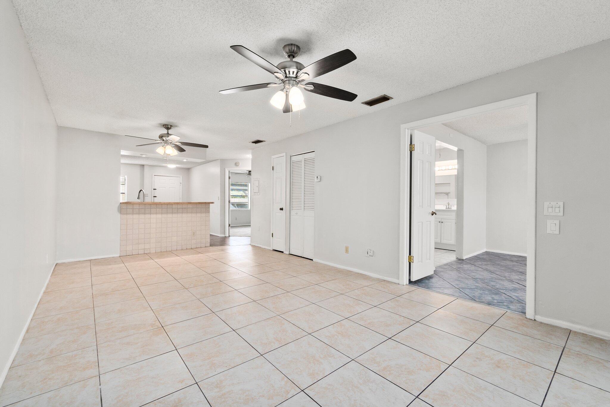 6012 Indrio Road, Unit E2 Fort Pierce, FL 34951 - Photo 5 of 25 a view of an empty room with cabinet and a ceiling fan