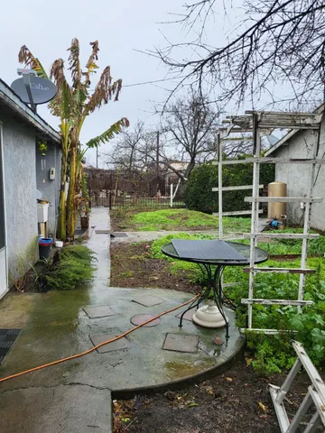 a view of a backyard with table and chairs potted plants