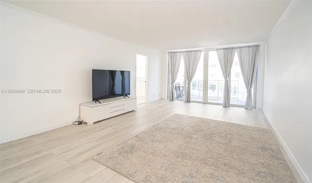 a view of an empty room with a window and a flat screen tv