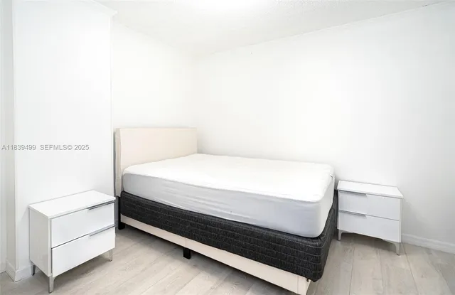 a bed sitting in a bedroom next to a white wall