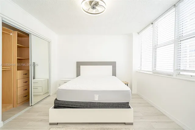 a living room with a bed and next to a window