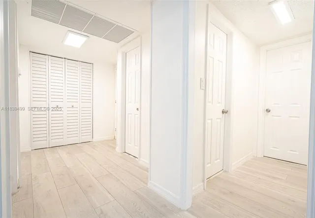 a view of a room with wooden floor and a window