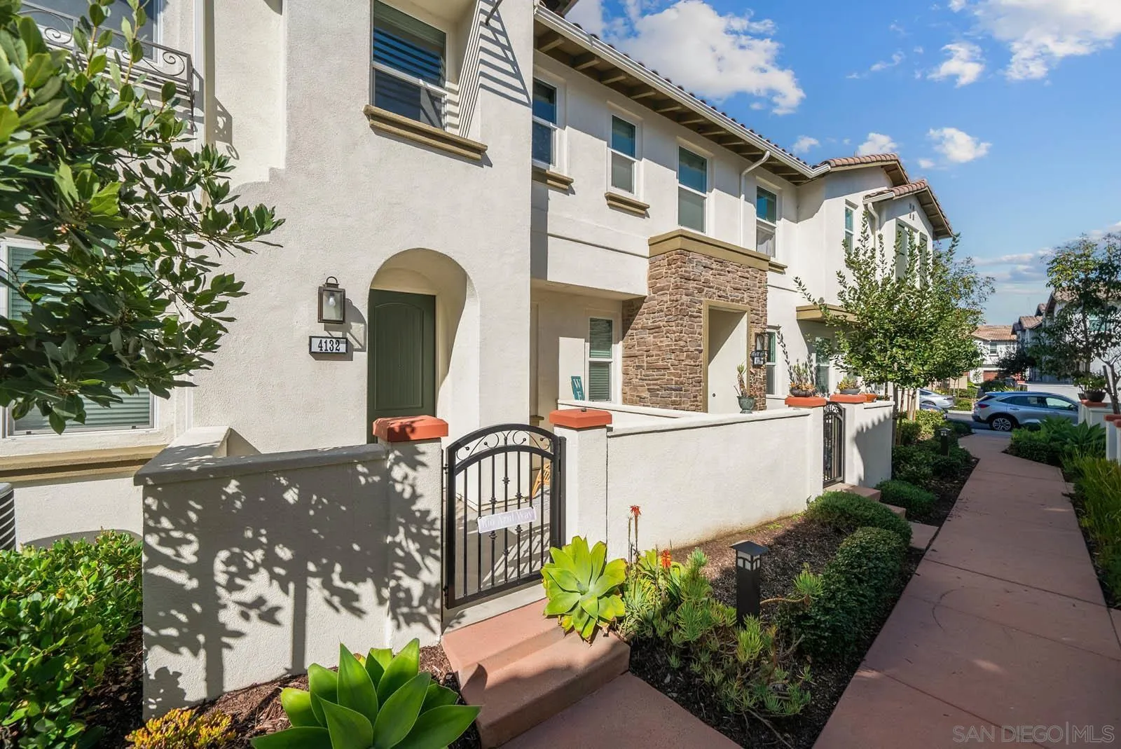 4132 Rio Azul Way Oceanside, CA 92057 - Photo 2 of 48 a view of a brick house with a flower plants and a bench