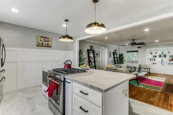 a view of a dining room and livingroom with furniture wooden floor a chandelier