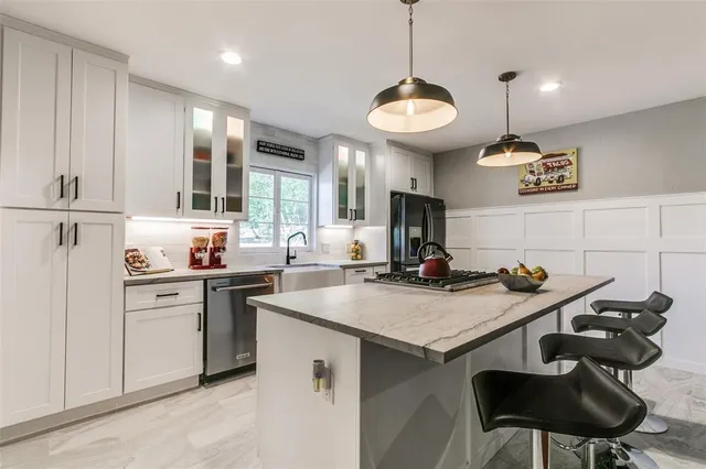 a kitchen that has a stove a table and chairs in it