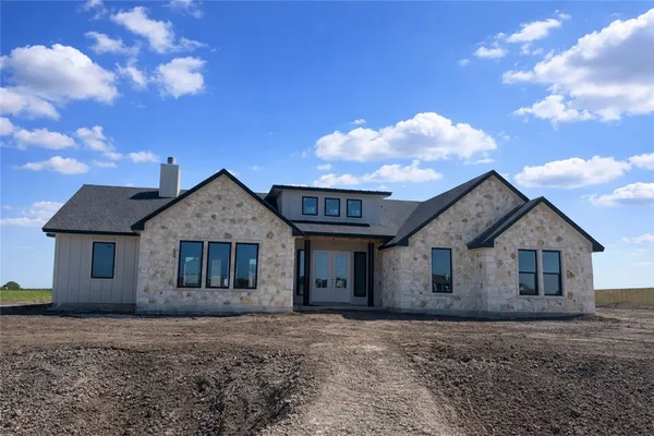 a view of a yard in front of a house with a large tree
