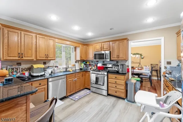 a kitchen with stainless steel appliances granite countertop sink stove top oven and cabinets