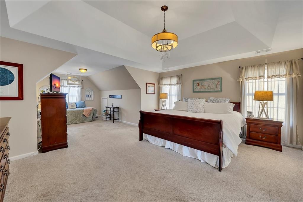 605 Garnet Court Canton, GA 30114 - Photo 30 of 75 a spacious bedroom with a bed and a chandelier