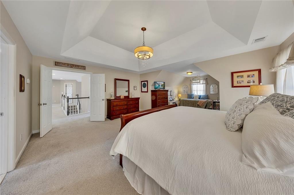 605 Garnet Court Canton, GA 30114 - Photo 31 of 75 a spacious bedroom with a large bed and a chandelier