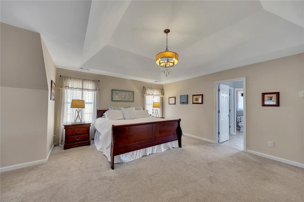 605 Garnet Court Canton, GA 30114 - Photo 34 of 75 a spacious bedroom with a bed and a table in it