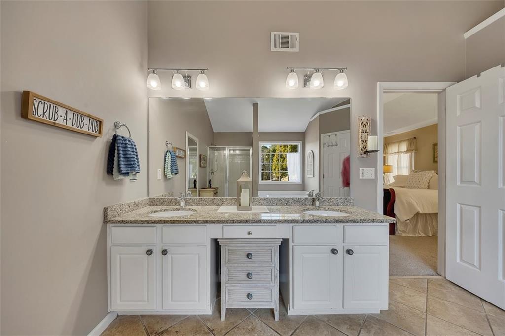 605 Garnet Court Canton, GA 30114 - Photo 36 of 75 a bathroom with a granite countertop sink double vanity and a mirror