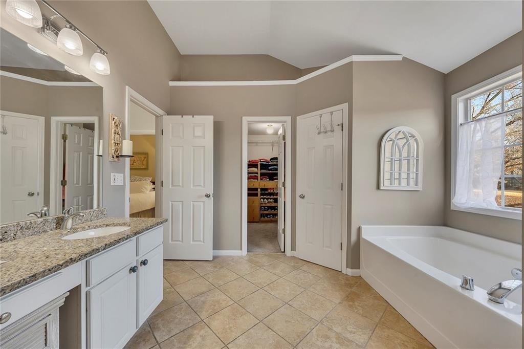 605 Garnet Court Canton, GA 30114 - Photo 37 of 75 a spacious bathroom with a granite countertop tub sink and mirror
