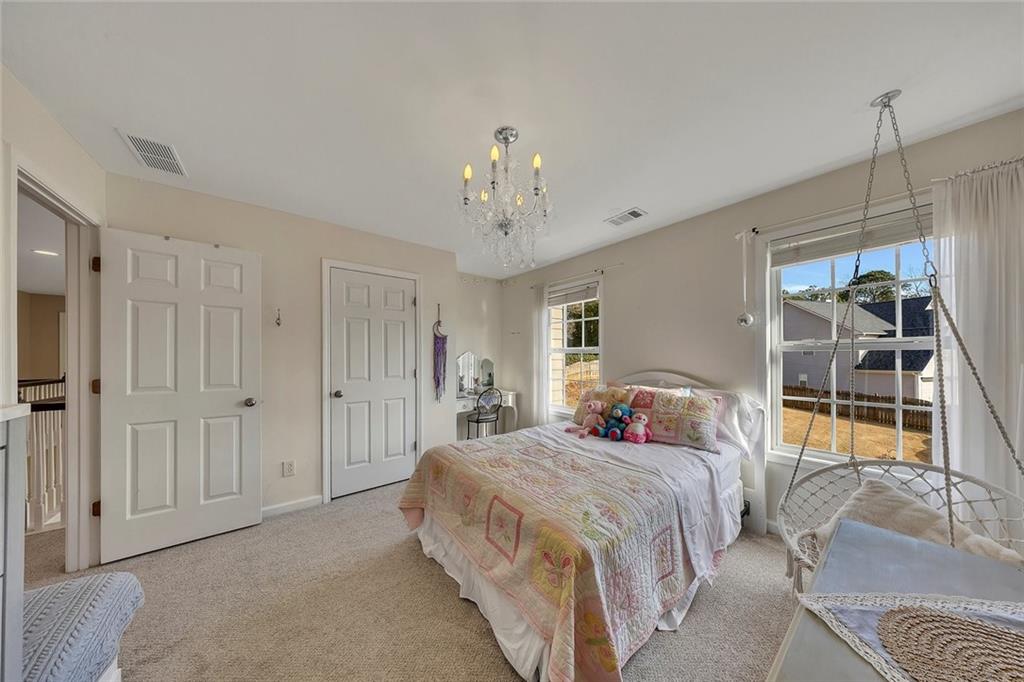 605 Garnet Court Canton, GA 30114 - Photo 40 of 75 a bedroom with a bed and a chandelier